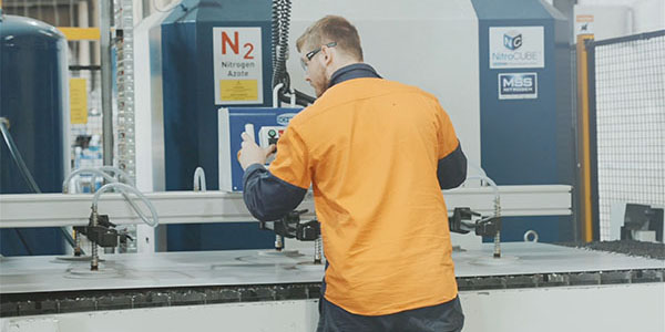 Worker in high visibility clothing operating manufacturing equipment